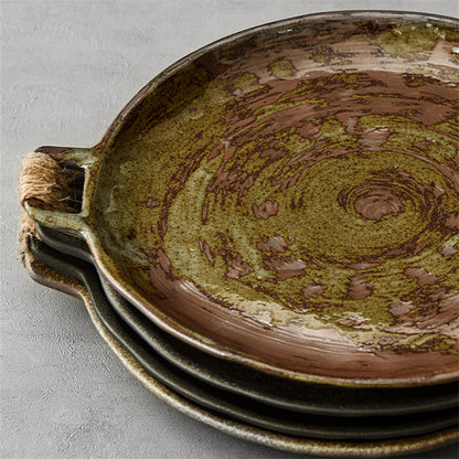 Round reactive-glaze serving plate styled with fruit on a table
