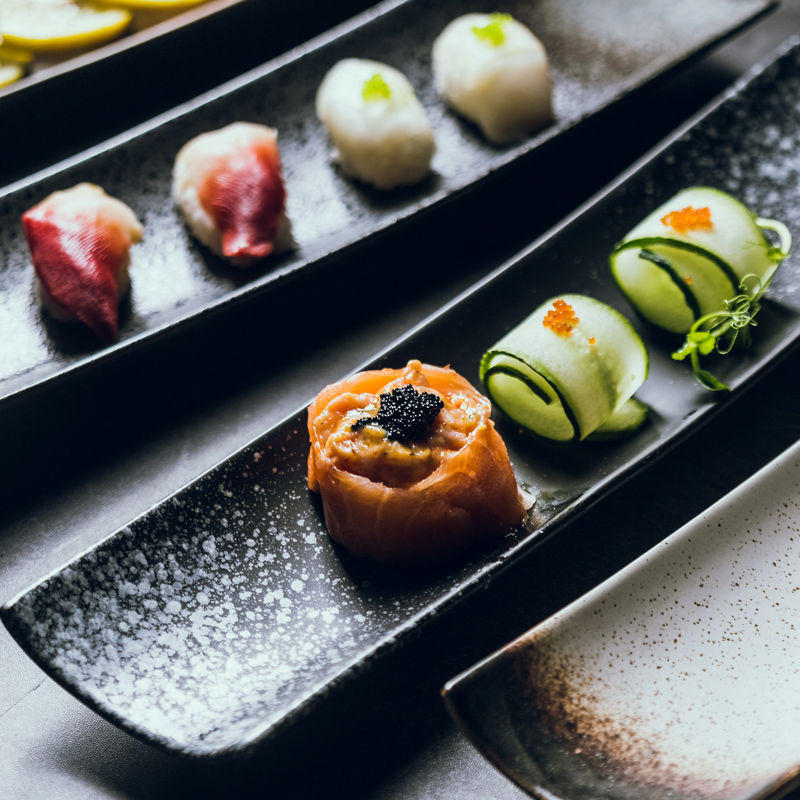 Slim ceramic boat plate styled for nigiri, dumplings and small bites