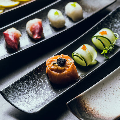 Slim ceramic boat plate styled for nigiri, dumplings and small bites