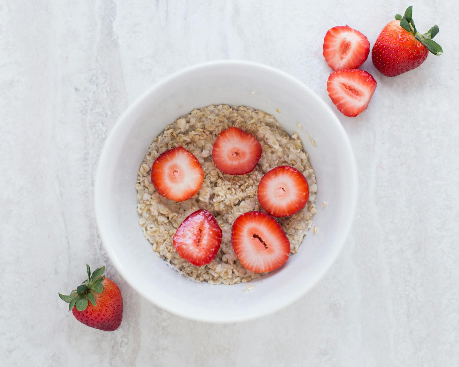Fresh strawberries beside a ceramic bowl