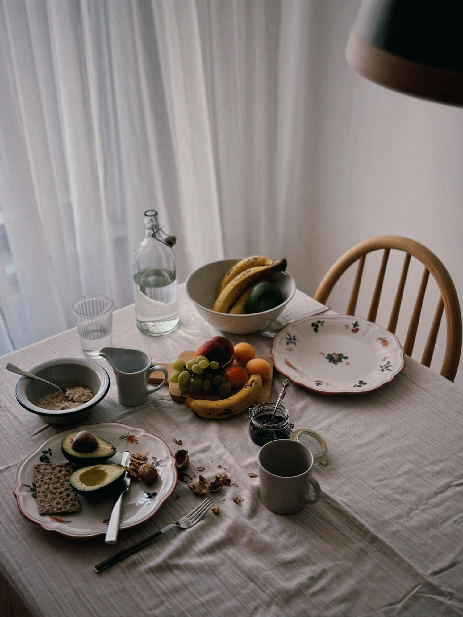 A warm breakfast table with fresh fruit in ceramic bowls